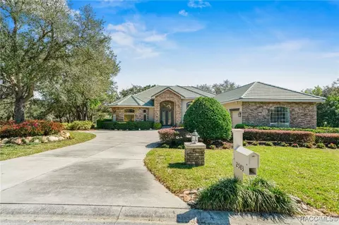 Front exterior of 2583 N Troon Path with stone facade, tile roof, and landscaped drive